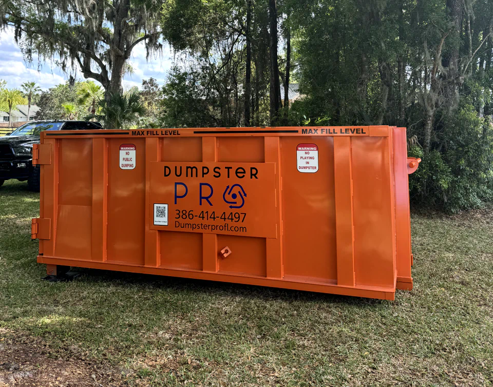 orange dumpster in the middle of s forest